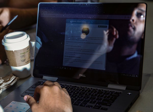 student reflected in the screen of his laptop during the Google Tech Challenge at UIC