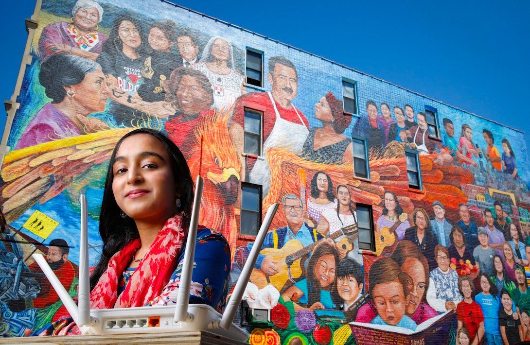 Afifa Nadeem in front of a mural in Pilsen by the artist Pablo Serrano