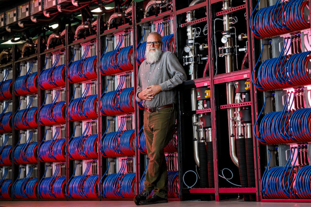 Michael E. Papka, a professor in UIC’s computer science department, stands with the Aurora supercomputer at Argonne National Laboratory.