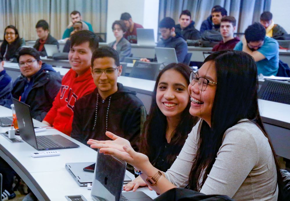 A group of undergraduate students laugh in CS 141 lecture.