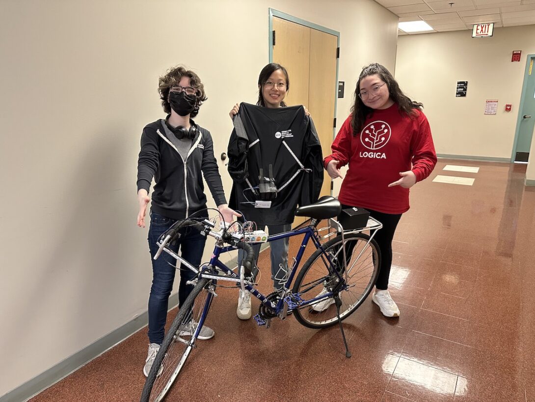 Polly Ruhnke, Annie You, and Emily Mendoza with a bicycle outfitted with the Lite-Bike