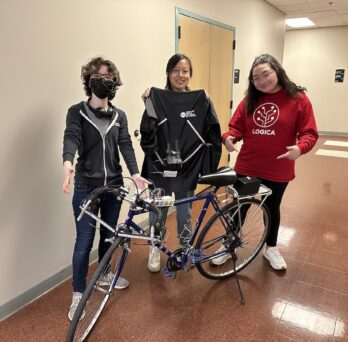 Polly Ruhnke, Annie You, and Emily Mendoza with a bicycle outfitted with the Lite-Bike 